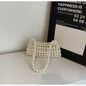 Detail of handmade pearl beaded crossbody bag featuring a woven rectangular structure
