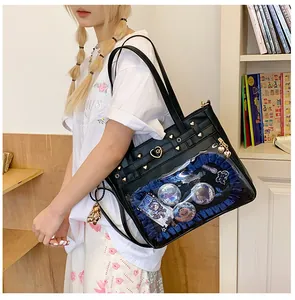 Detalle del bolso Ita negro con ventana transparente, volantes azules y corazones dorados