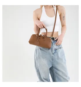 Brown leather Boston bag with round pendant shown on a model for daily styling