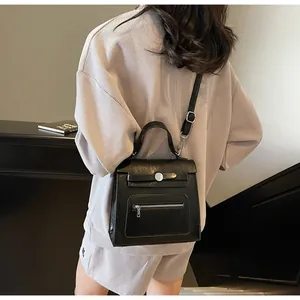 Detail of a black leather multi-functional backpack worn over the shoulder by a model