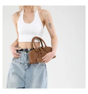 Close-up of brown litchi grain leather tote bag with FASHION tag and metallic zipper