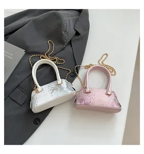 Detail of pink and white faux-snakeskin mini shell bags with elegant gold chain straps