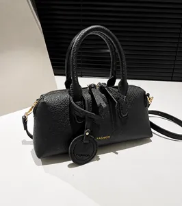 Detail of black pebbled leather tote bag with gold lettering and adjustable strap