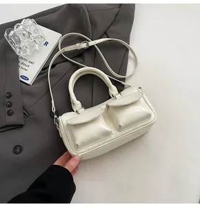 Close-up of cream PU leather handbag featuring two front pockets and silver hardware details