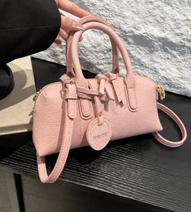 Pink lychee grain leather Boston bag detail with dual handles and fashion fringe tassels