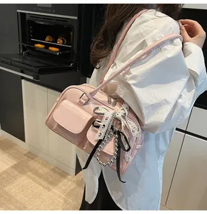 Dettaglio della borsa Boston in vernice rosa con nastri alla moda e ciondoli di perle