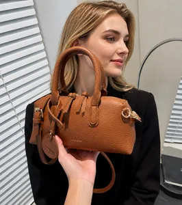 Detail of brown litchi pattern leather boston bag with embossed fashion text and strap