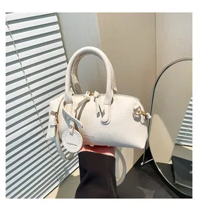 Close-up of off-white lychee leather texture and dual zipper detail on tote bag
