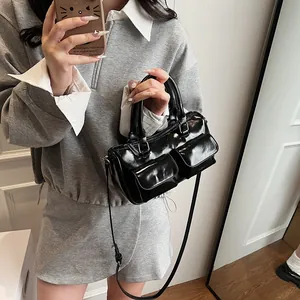 Glossy black handbag with double front pockets and adjustable shoulder strap for women
