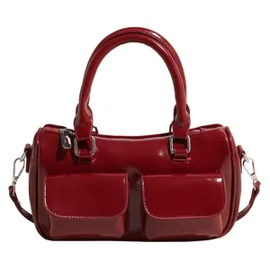 Glossy dark red leather shoulder bag with dual front pockets and top handles