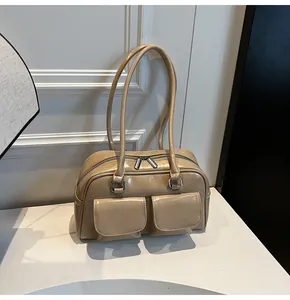 Dettaglio della borsa in pelle verniciata beige chiaro con doppie tasche e inserti in argento