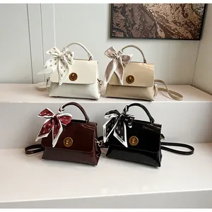 Detail of four colorful handbags with fashion silk scarves and round metal twist locks
