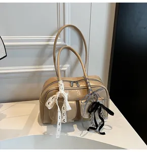Dettaglio della borsa Boston beige in vernice con lacci in pizzo e nastro a scacchi