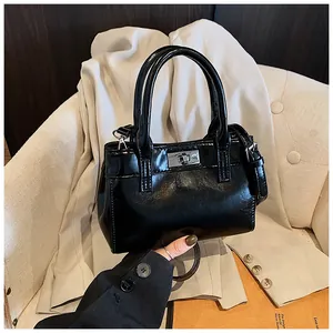 Detail einer schwarzen glänzenden kleinen Tasche mit silbernem Metalldrehverschluss