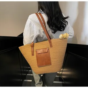 Détail du sac cabas tissé avec bandoulière en cuir marron et poche frontale décorative