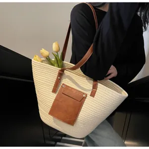 Détail d'un grand sac cabas tissé avec une poche à rabat en cuir et des tulipes