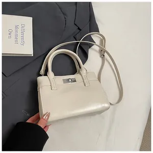 Detailansicht der cremeweißen Lederhandtasche mit Silberverschluss und feinen Nähten
