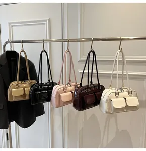 Dettaglio di cinque borse Boston lucide su supporto con doppie tasche frontali applicate