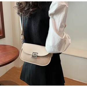 Detail view of a vintage saddle bag with cream leather flap and woven straw texture