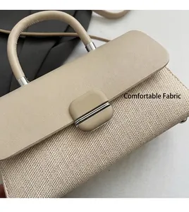 Détail de la texture tissée beige et du rabat en cuir lisse sur un petit sac carré