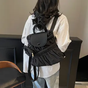 Sac à dos chic en nylon plissé noir avec rabat magnétique et pochette par mannequin