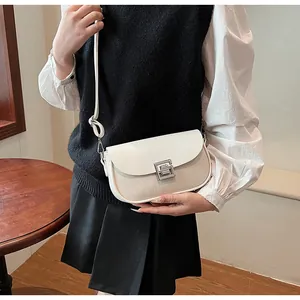 Model wearing a vintage saddle bag featuring white leather and beige woven texture details