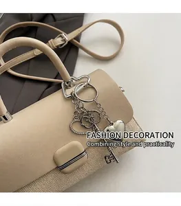 Détail du sac à main crème élégant avec textures mixtes, fermoir métal et breloques
