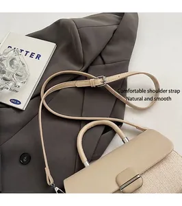Détail d'un sac bandoulière beige avec sangle réglable et texture tissée élégante