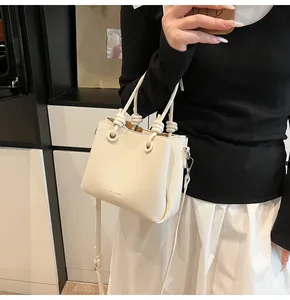 Detail of white lychee pattern leather bucket bag with knotted handle and clear logo