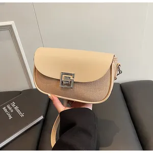 Detail of beige canvas saddle bag with khaki leather trim and silver geometric buckle