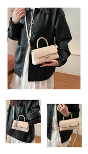 Détail d'un sac à bandoulière minimaliste crème avec texture tressée et fermoir métallique