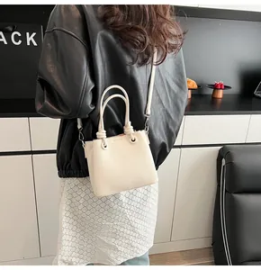 Gros plan détaillé du sac en cuir crème avec ses poignées nouées au design unique