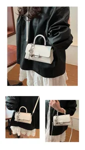 Gros plan du sac à main beige avec fermoir argenté et charm clé en forme de cœur