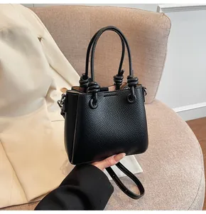 Gros plan détaillé du sac à main en cuir noir grainé avec détail de poignée nouée chic