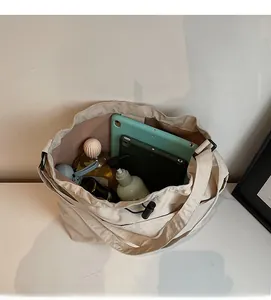 Vue intérieure détaillée du sac seau en nylon beige montrant le grand espace de rangement