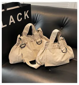 Close-up of beige canvas handbag set with ruffled edges and sleek black metal hardware