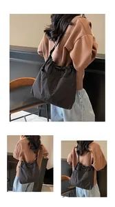 Vue détaillée des grandes poches avant et du cordon de serrage du sac seau noir en nylon