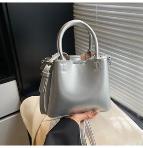 Detail view of silver bucket bag showing CLEAROK logo and shiny metallic leather texture