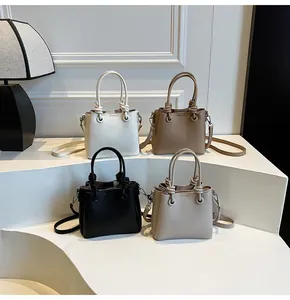Détail montrant des sacs seaux en quatre couleurs avec poignées nouées et grain galet