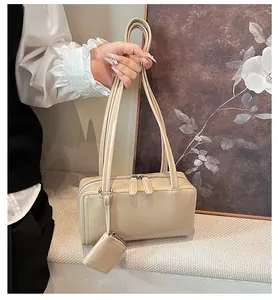 Dettaglio borsa a spalla beige minimalista con mini portamonete e doppia cerniera superiore