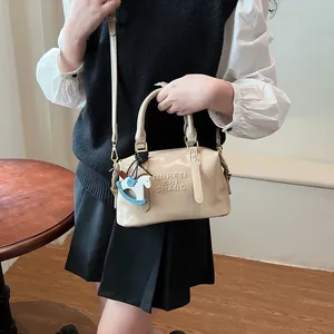 Borsa a tracolla beige minimalista con ciondolo a forma di cavallo a dondolo e catena