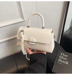Détail du sac à main élégant en cuir crème et toile avec fermoir métallique et bandoulière
