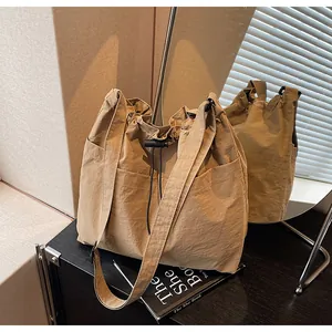 Vue détaillée du sac en nylon kaki avec poche latérale à cordon et texture plissée