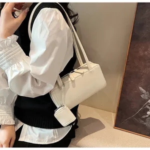 Dettaglio borsa sottobraccio crema minimalista con mini pochette coordinata e zip argentata