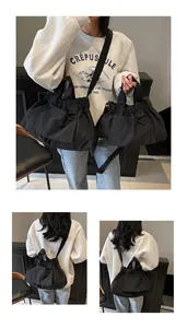 Detail of black pleated nylon tote bag with adjustable shoulder strap and metal ring