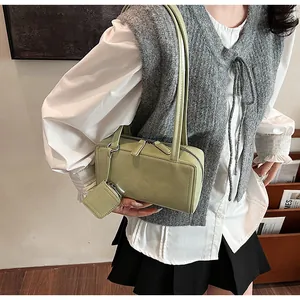 Dettaglio della borsa a spalla in pelle verde avocado con ciondolo portamonete rotondo abbinato