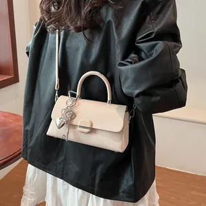 Sac à bandoulière beige chic avec breloques argentées et détails en cuir tissé