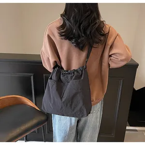 Vue de dos d'un mannequin portant un sac seau noir en nylon avec de grandes poches