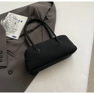 Detail view of black lychee leather bag with white contrast stitching and soft texture