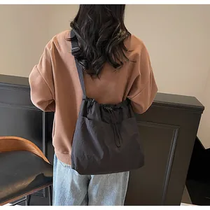 Détails d'un grand sac en nylon noir à cordon avec texture plissée et poches frontales